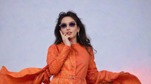 una mujer con un vestido naranja y gafas de sol fumando un cigarrillo y mirando a la cámara con una expresión seria en su rostro, Elina Karimova, naranja, portada de un álbum, prensa privada