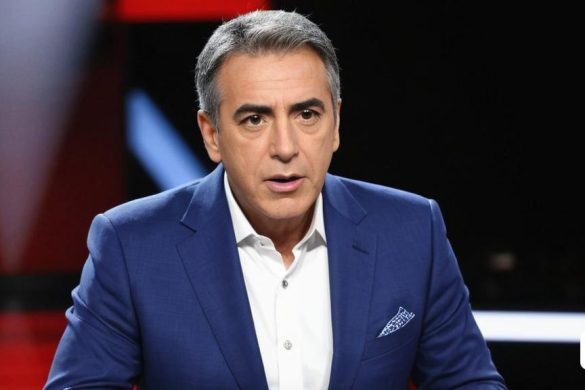 un home amb un vestit blau i camisa blanca assegut amb les mans als malucs i un micròfon a la mà, Daryush Shokof, 8 k alta definició, un retrat, plasticien