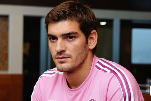 un home amb camisa rosa assegut a una taula amb una copa de vi davant i una ampolla de vi davant, Carles Delclaux És, guapo, una escultura de bronze, plasticien