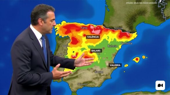 Una imagen detallada del meteorólogo Roberto Brasero brindando un pronóstico del tiempo para España. Se lo ve haciendo gestos con las manos mientras está de pie frente a un colorido mapa meteorológico que muestra diferentes regiones de España. El mapa muestra diferentes tonos que representan áreas con potencial de lluvia y tormentas, con énfasis en regiones como Valencia, Baleares y el noreste peninsular. En el fondo, se ven símbolos de nubes de lluvia y sol, que indican las diversas condiciones climáticas esperadas. La expresión de Roberto Brasero transmite seriedad y concentración mientras brinda información meteorológica importante a los espectadores.