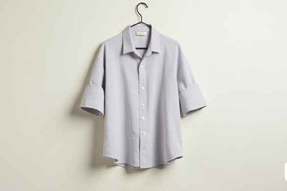 Una elegante y moderna 'camisa' se muestra prominentemente en un fondo limpio y minimalista. La camisa está hecha a partir de una 'mezcla' de 'lino' y 'algodón', que muestra una textura ligera y aireada que sugiere 'comodidad' y 'frescura'. Su 'ajuste suelto' permite una silueta relajada, lo que la hace adecuada para varios tipos de cuerpo. El 'collar' está elegantemente diseñado con una 'solapa', agregando un toque de sofisticación al aspecto general. La camisa presenta un clásico 'Stripe Pattern', que mejora su atractivo contemporáneo, lo que lo hace versátil para diferentes ocasiones. La 'tela' parece suave y duradera, insinuando su calidad duradera. La camisa está cuidadosamente colgada de una percha simple, con una luz suave que ilumina sus características, enfatizando la 'facilidad de cuidado', ya que se puede lavar a 40 ° C sin tratamientos especiales. Debajo de la camisa, una etiqueta de precio lee '9,99 euros', destacando su asequibilidad. La imagen captura la esencia de la adaptabilidad de la camisa